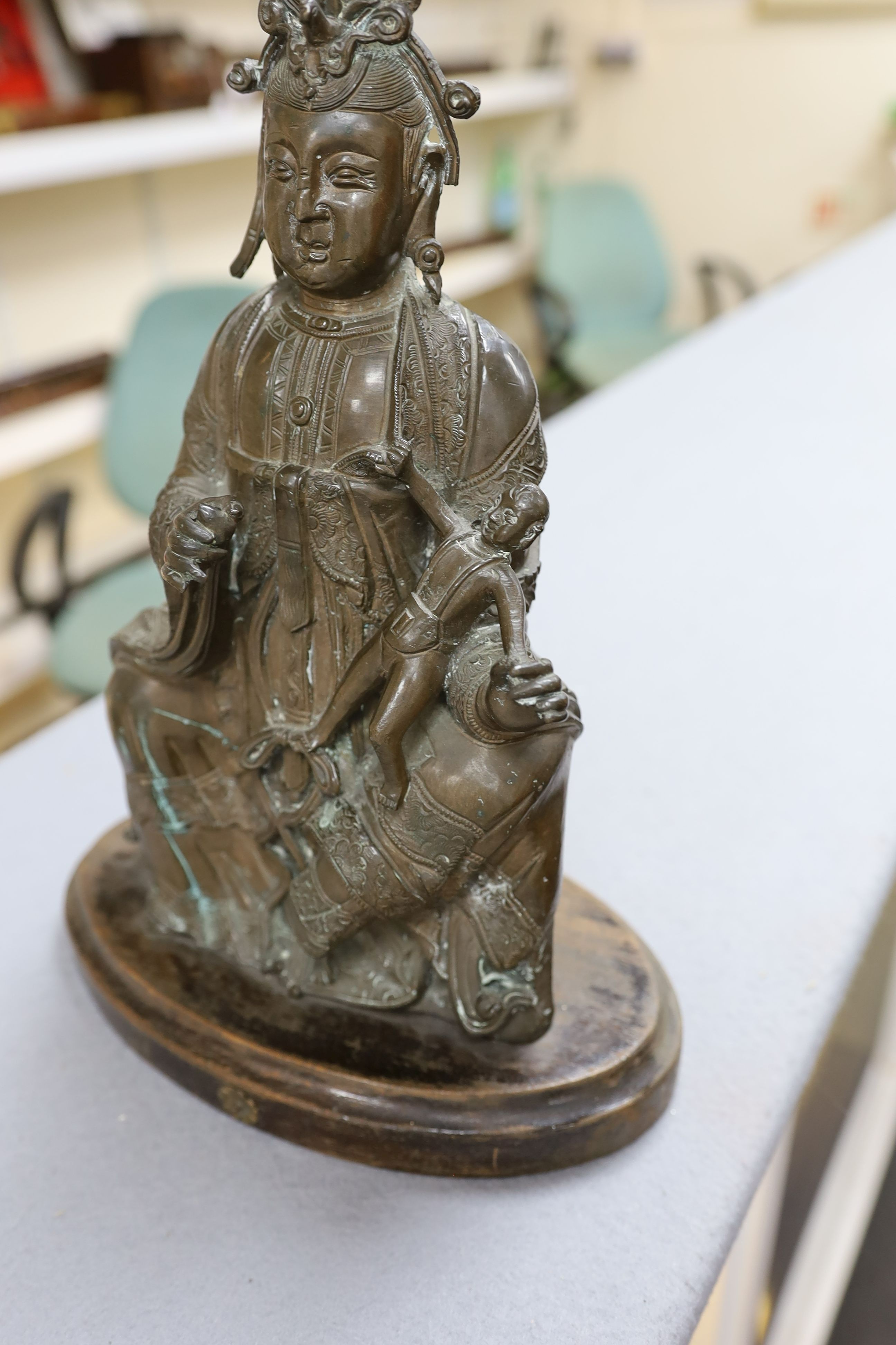 A large Chinese bronze group of Xi Wangmu and a child, late Ming dynasty, 31.5cm high excluding later wood stand